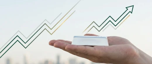 Gold Price Trader: Hand holding a silver bar with upward trend lines, symbolizing silver's long-term investment growth.